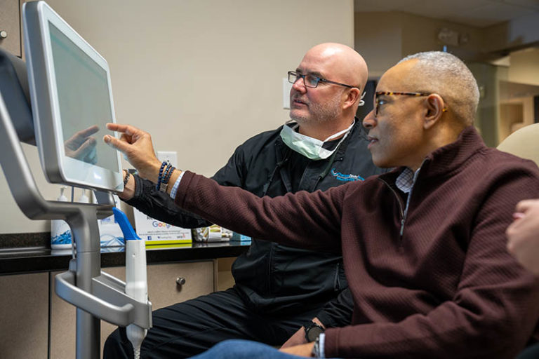 charlotte dental arts dentist dr porter showing male African american patient his digital x ray