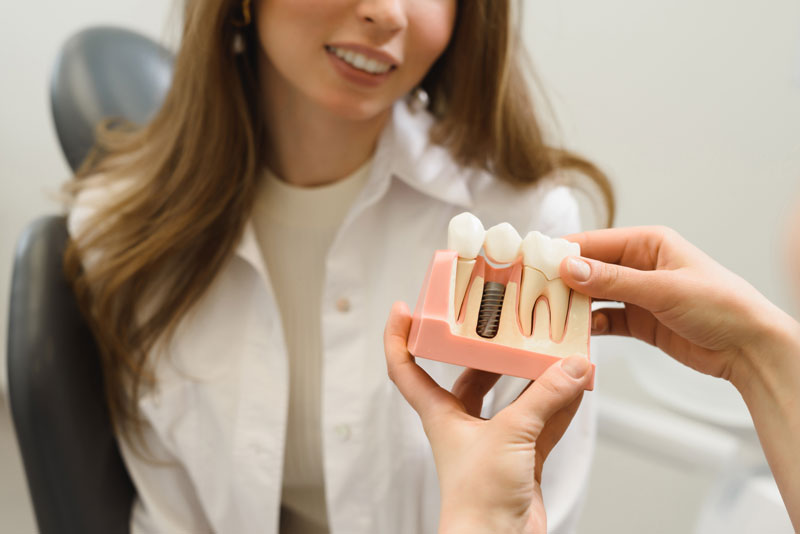 Dental Patient Getting Shown A Dental Implant Model During Her Consultation in Charlotte, NC