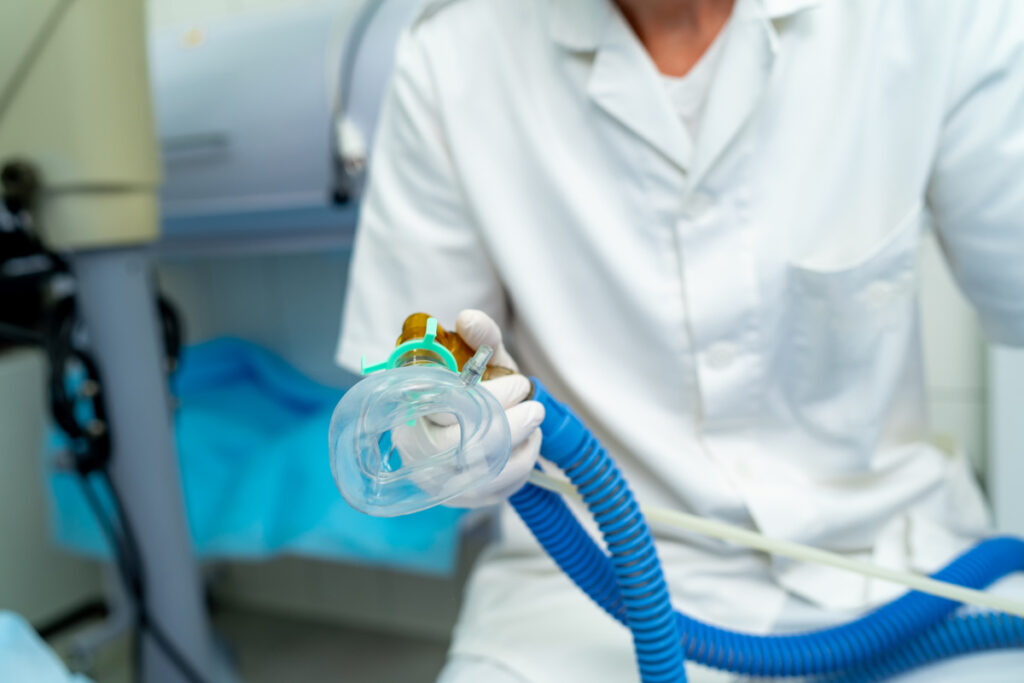 Mask for anesthesia in operating room. Unrecognizible doctor holds mask in hands. Closeup.