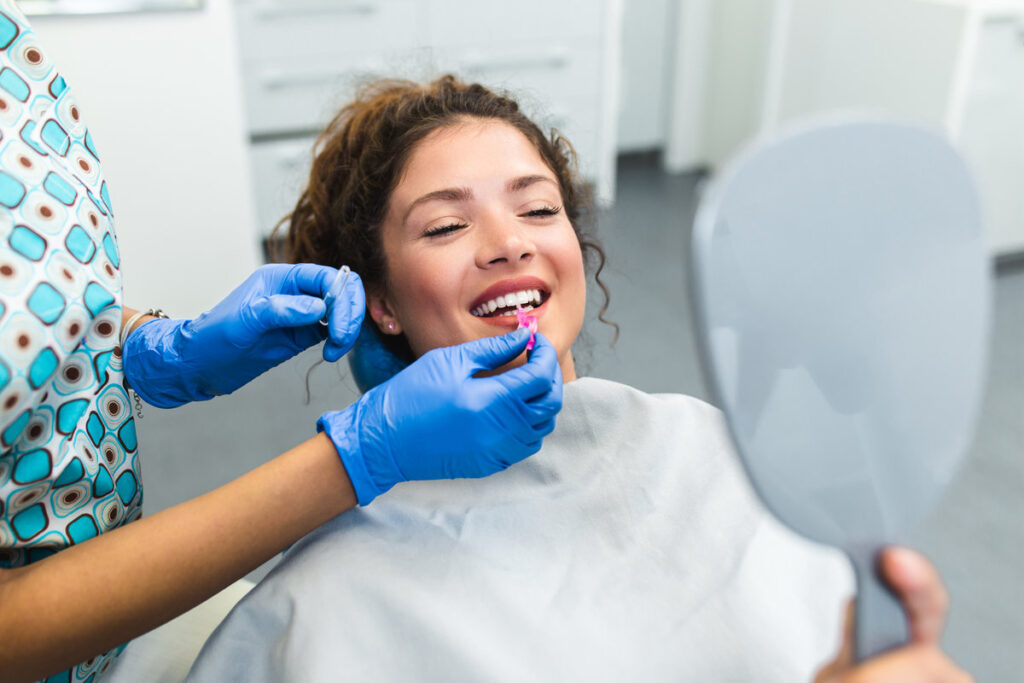 Beautiful young woman having dental treatment at dentist's office.
