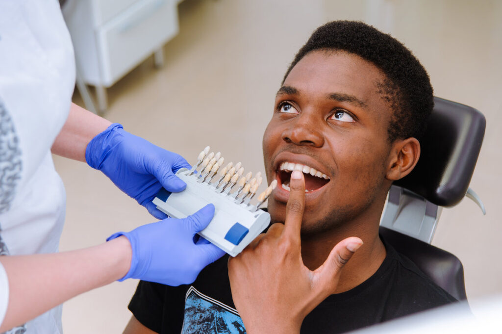 Check and select the color of the teeth. Dentist makes the process of treatment in dental clinic.