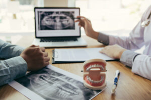 Dentists are discussing dental problems at report x-ray image on