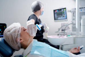 Doctor making anesthesia while female patient lying in dentist chair