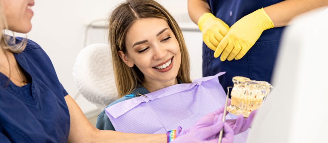a dentist teaching a dental implant patient about the implant procedure and treatment.
