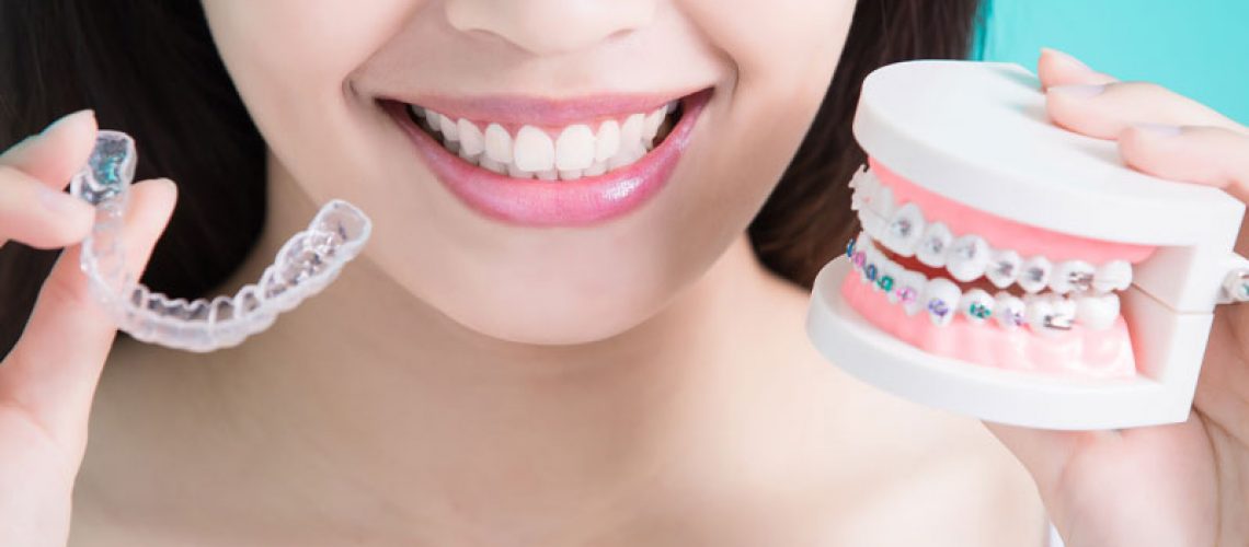 Dental Patient Holding Up Invisalign Retainers